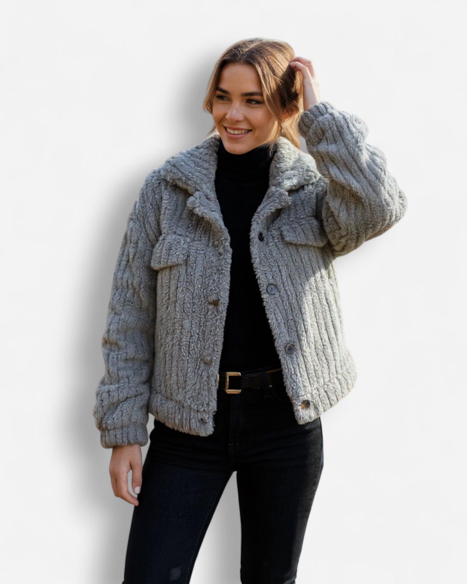 Frau trägt eine graue Sherpa-Jacke vor weißem Hintergrund