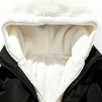 Nahaufnahme einer schwarzen Jacke mit weißem Fleecefutter vor weißem Hintergrund