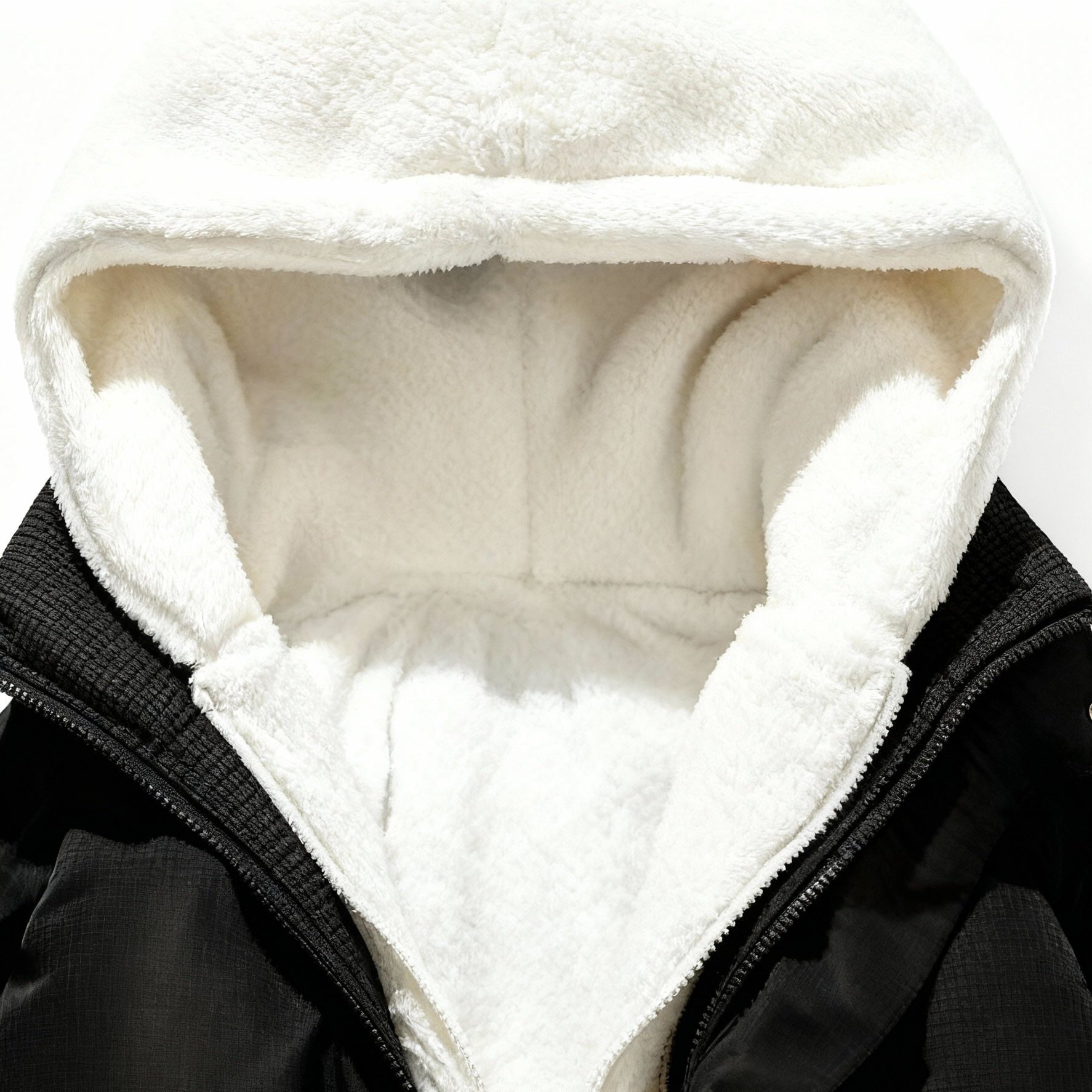 Nahaufnahme einer schwarzen Jacke mit weißem Fleecefutter vor weißem Hintergrund