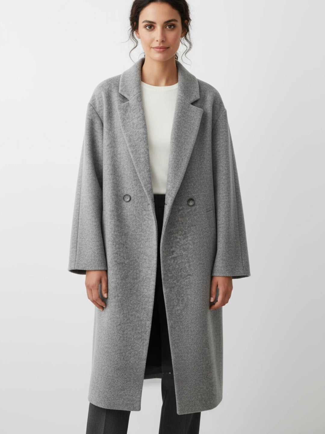 Frau trägt einen grauen Mantel vor weißem Hintergrund
