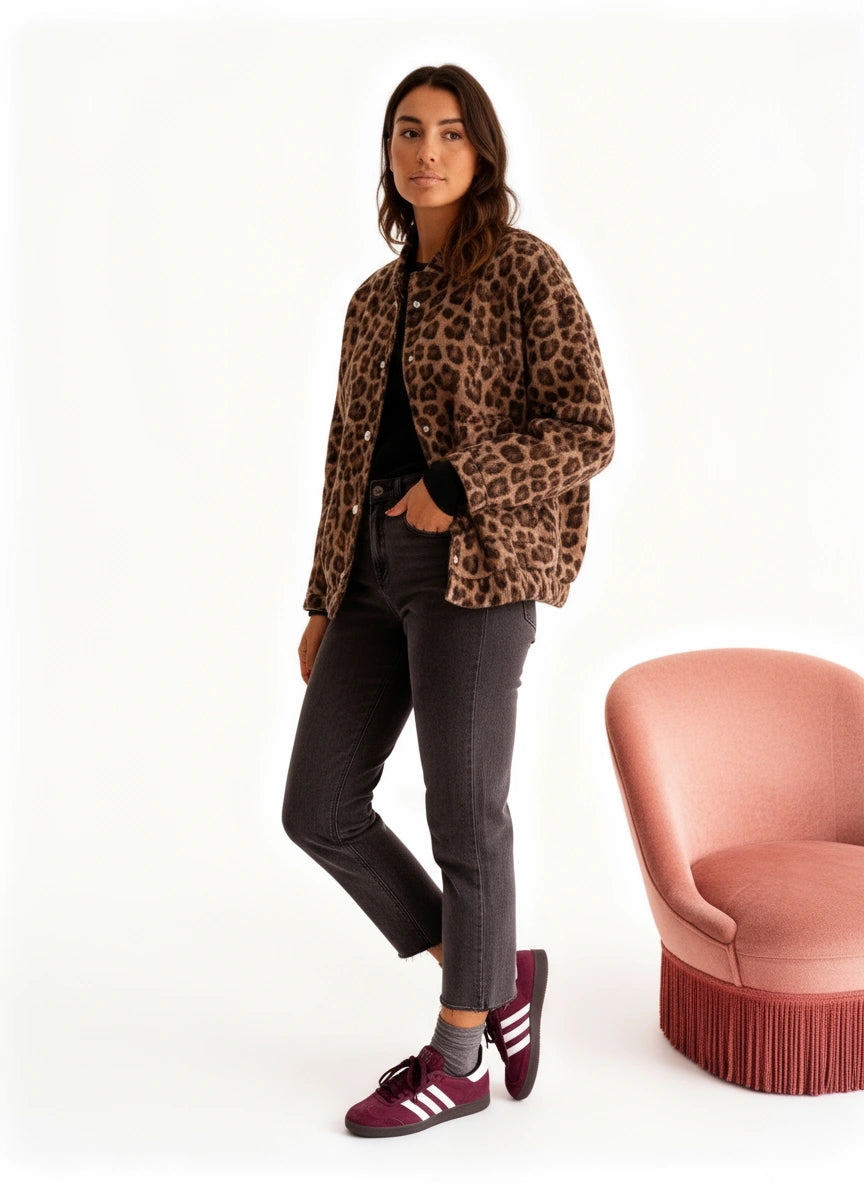 Frau trägt eine Blousonjacke, im Hintergrund steht ein rosa Stuhl