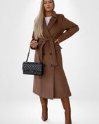 Frau trägt einen braunen Mantel mit Gürtel