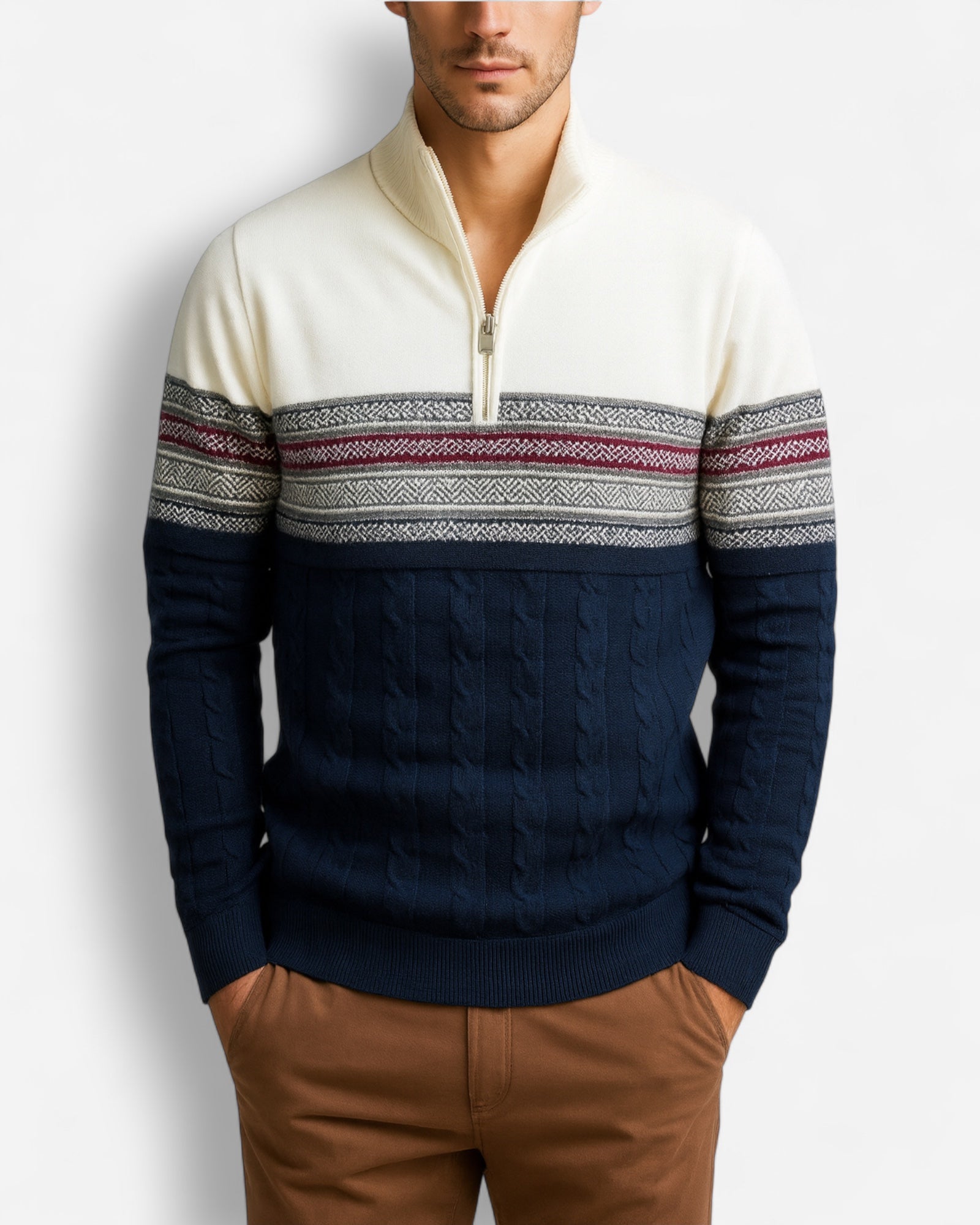 Mann trägt einen dunkelblauen und cremefarbenen Half-Zip-Pullover mit Zopfmuster und nordischem Design vor hellgrauem Hintergrund