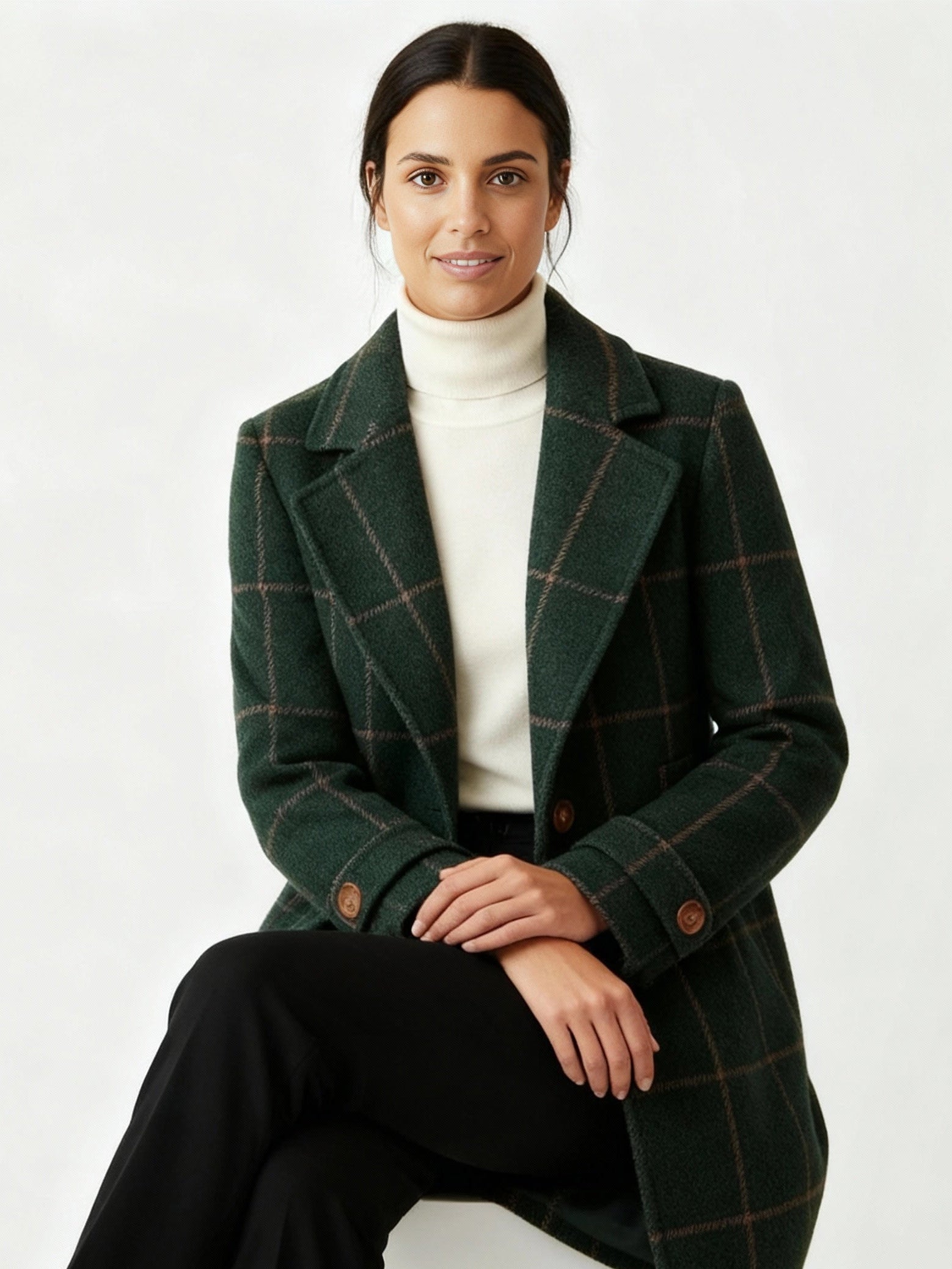 Frau trägt einen grünen karierten Mantel vor weißem Hintergrund 2