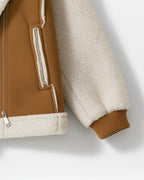 Nahaufnahme der gerippten Ärmelbündchen und Reißverschlusstaschen einer Jacke