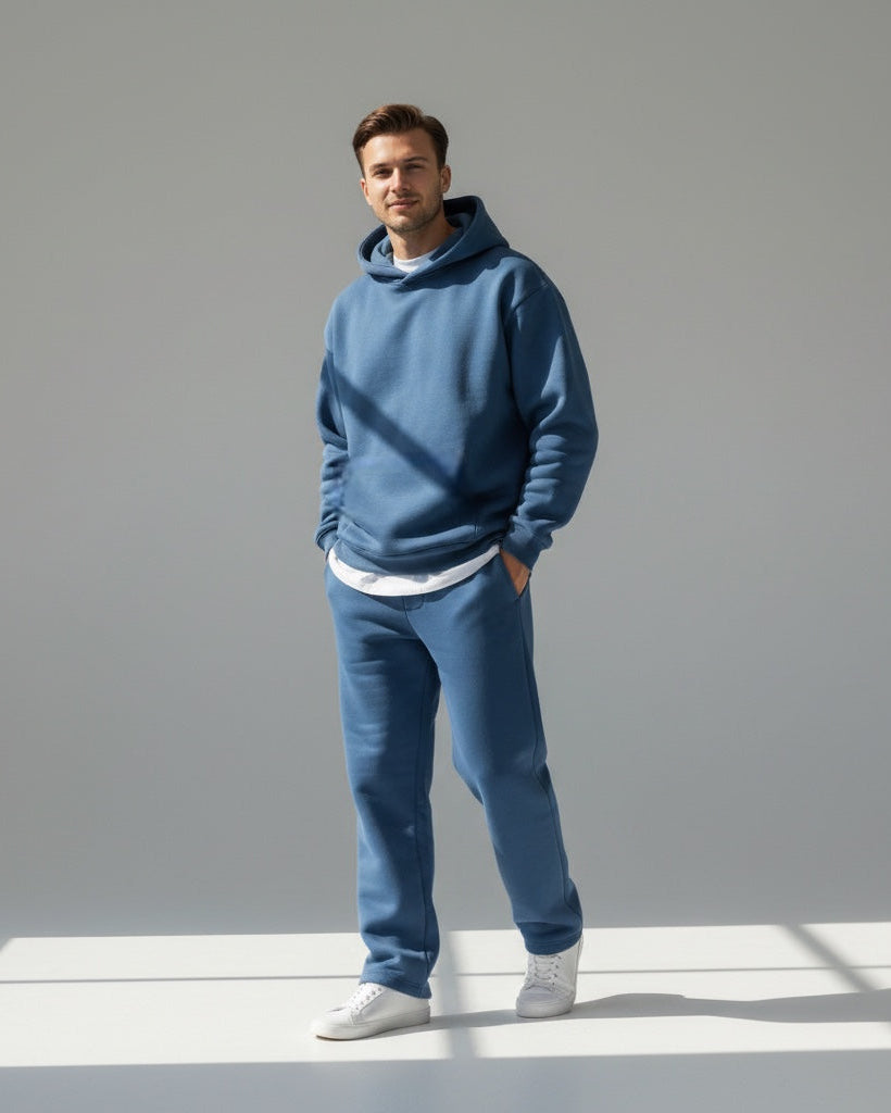 Ein Mann trägt ein blaues Oversized-Loungewear-Set mit Kapuzen-Sweatshirt und Jogginghose 1
