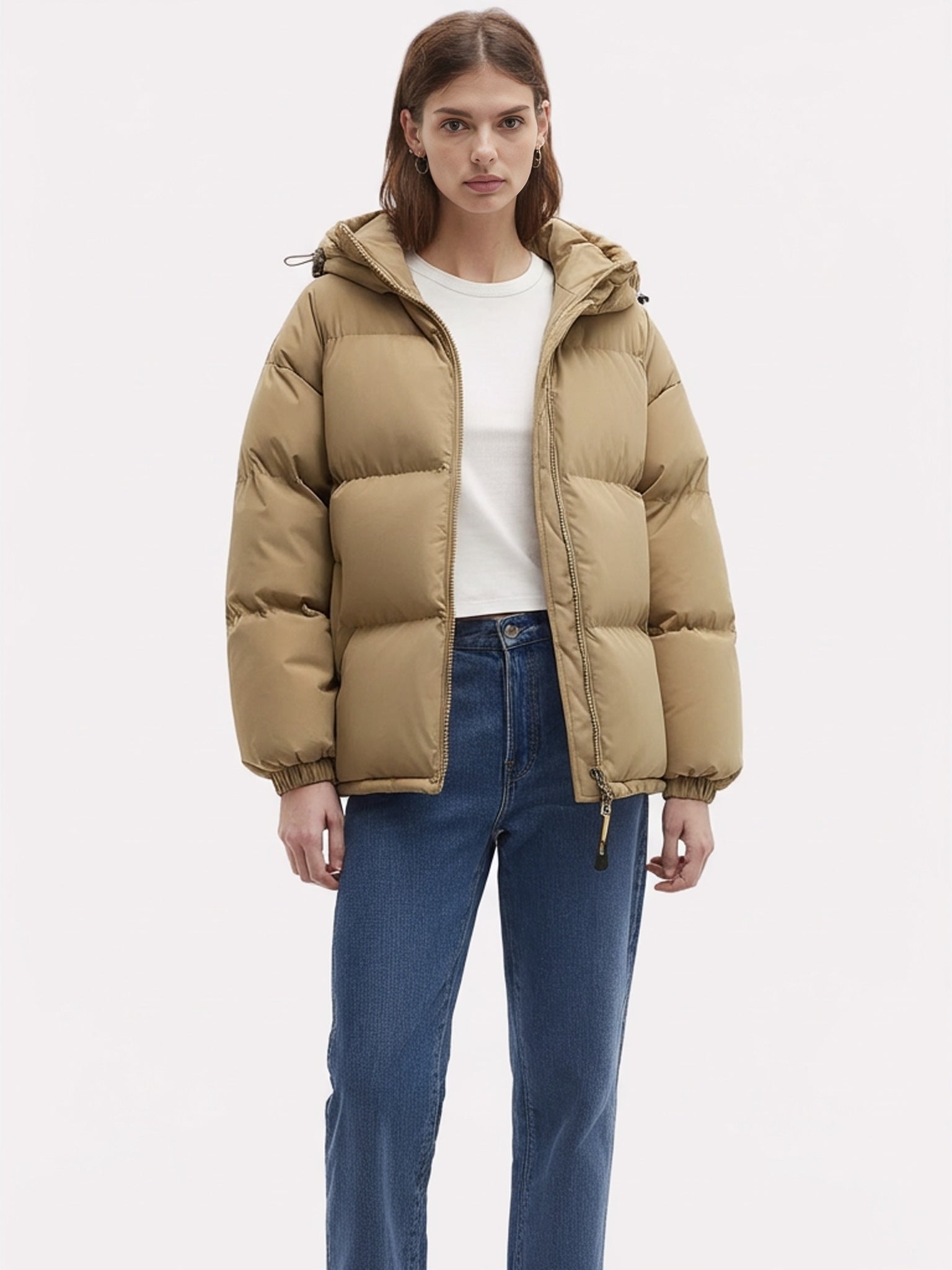 Frau trägt eine voluminöse hüftlange Jacke vor weißem Hintergrund