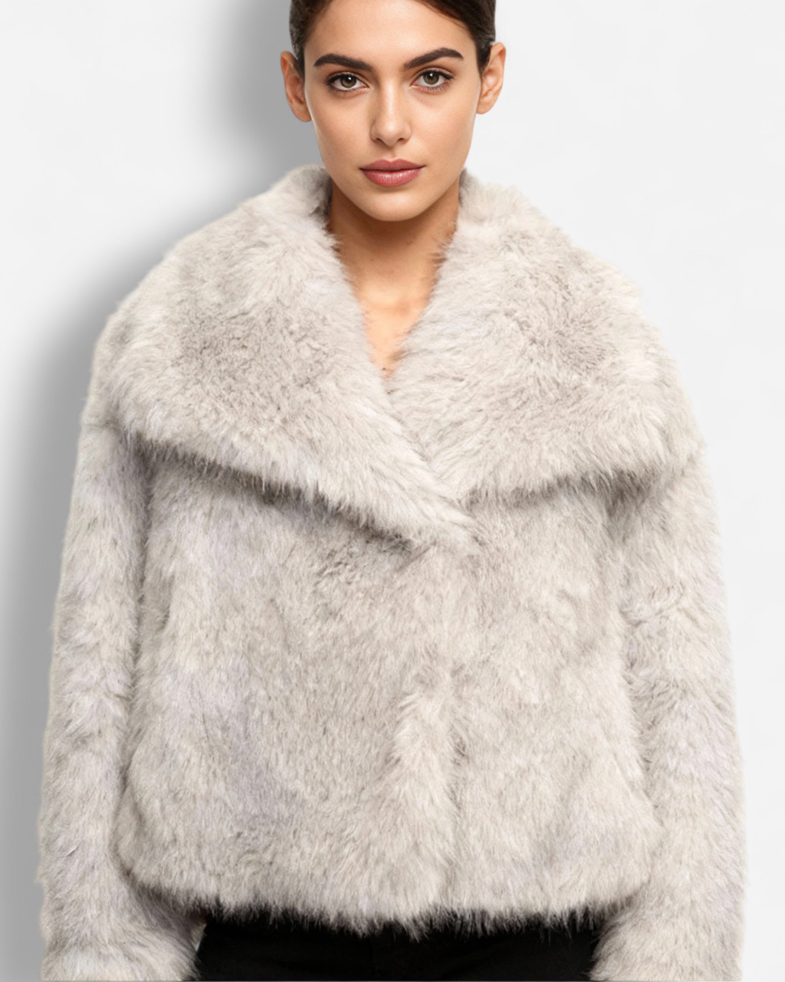 Frau trägt eine ecrufarbene flauschige Jacke vor einfarbigem Hintergrund