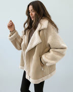 Frau trägt eine beige Jacke mit weichem Futter vor hellem Hintergrund