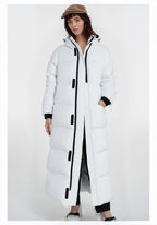 Person trägt einen langen weißen Puffermantel mit schwarzen Akzenten