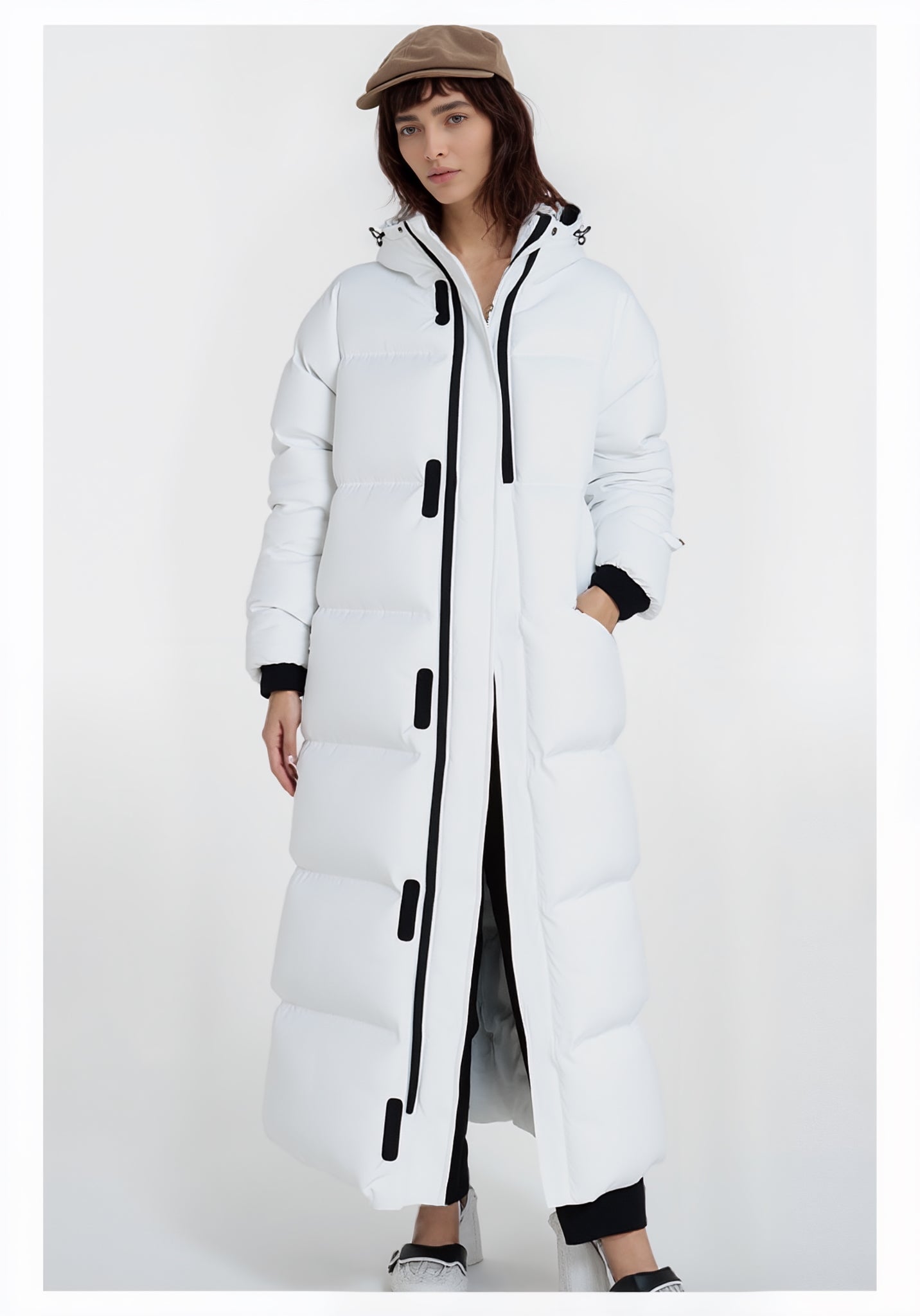 Person trägt einen langen weißen Puffermantel mit schwarzen Akzenten