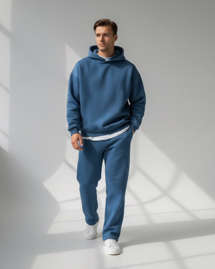 Ein Mann trägt ein blaues Oversized-Loungewear-Set mit Kapuzen-Sweatshirt und Jogginghose 0