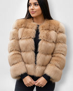 Frau trägt eine braune Webpelzjacke vor weißem Hintergrund