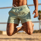 Kurze Herren Badeshorts mit Gummibund im Streifenmuster - Grün-weiße Streifen Badeshorts mit Gummibund, sportlicher Sprung am Strand