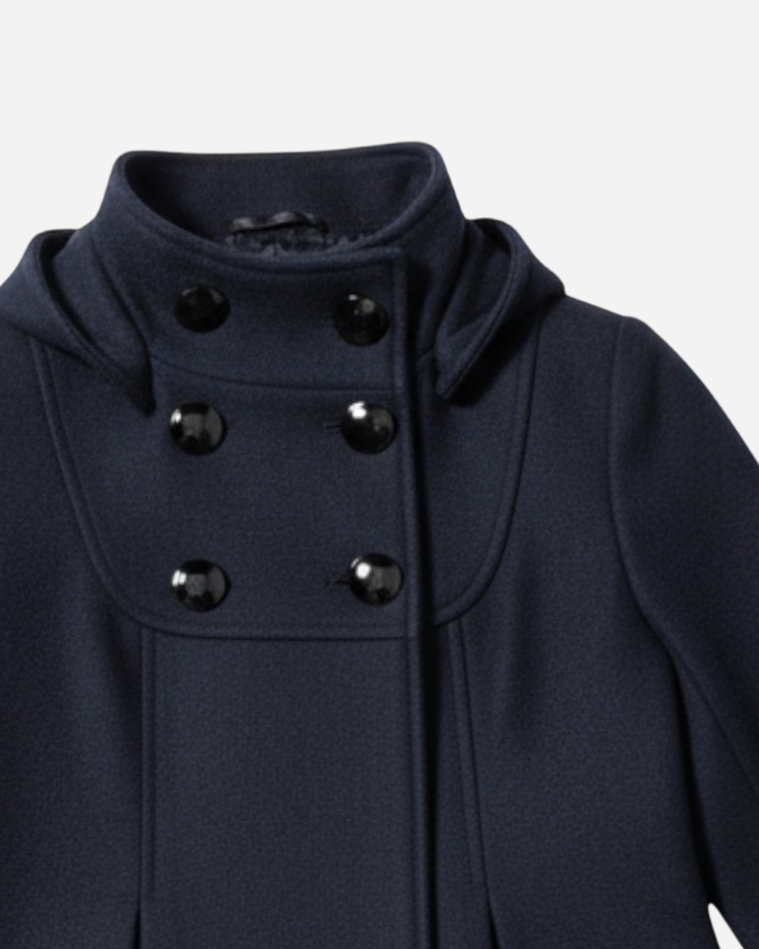 Nahaufnahme eines schwarzen Mantels mit schwarzen Knöpfen vor hellgrauem Hintergrund