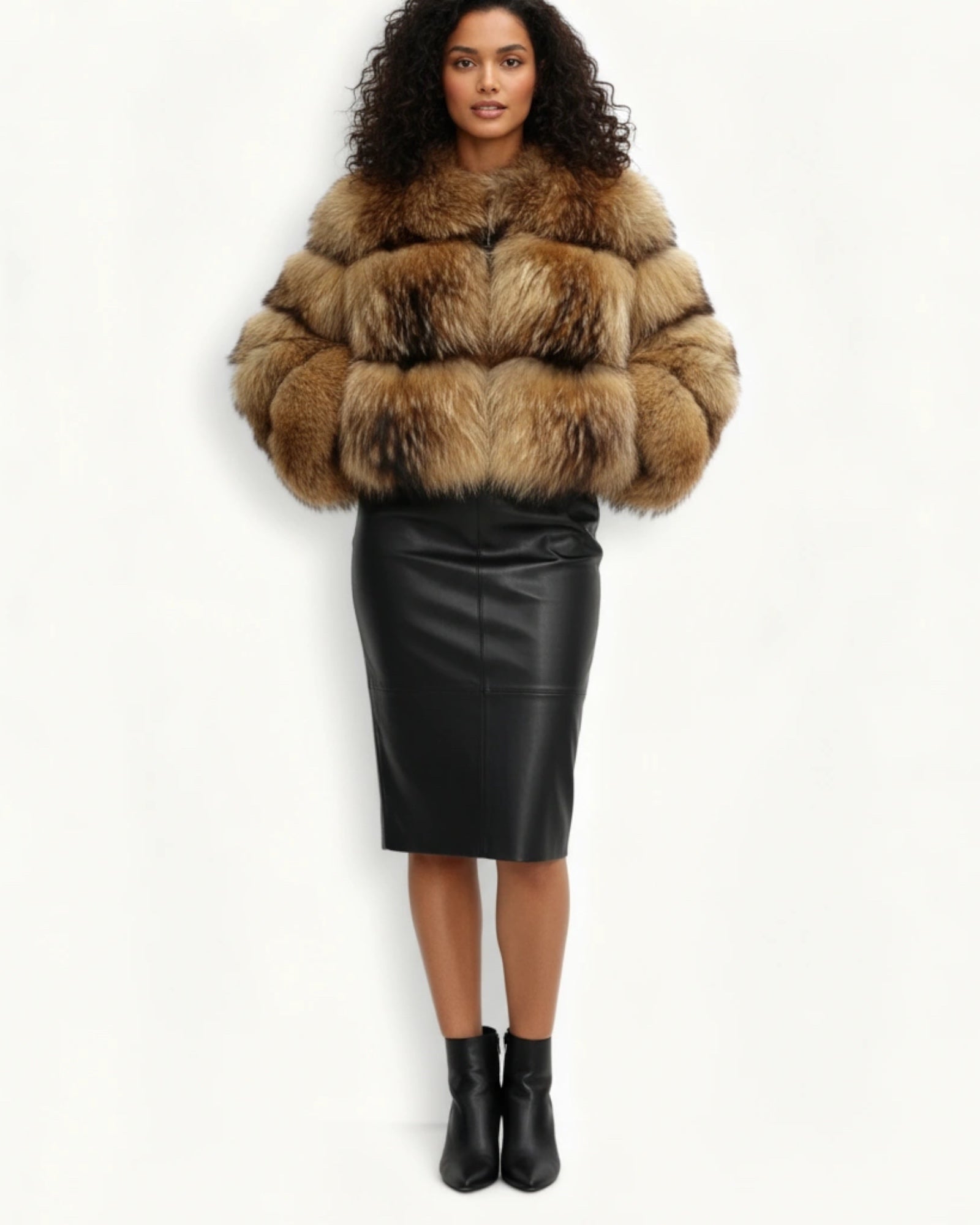 Frau in einem Kunst-Pelzmantel und schwarzem Lederrock vor weißem Hintergrund