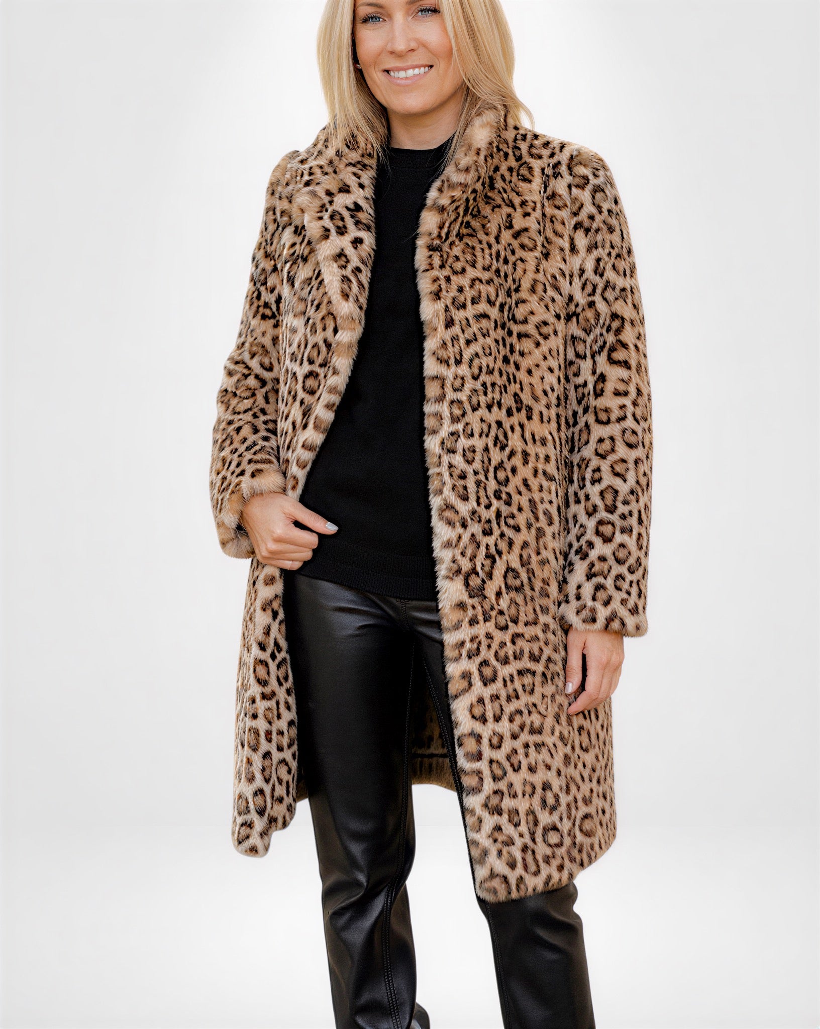 Frau trägt einen knielangen Mantel mit Leopardenmuster vor weißem Hintergrund